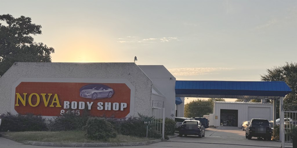 The Nova Body Shop sign and service canopy at 8415 North Lamar Boulevard in Austin, at sunset