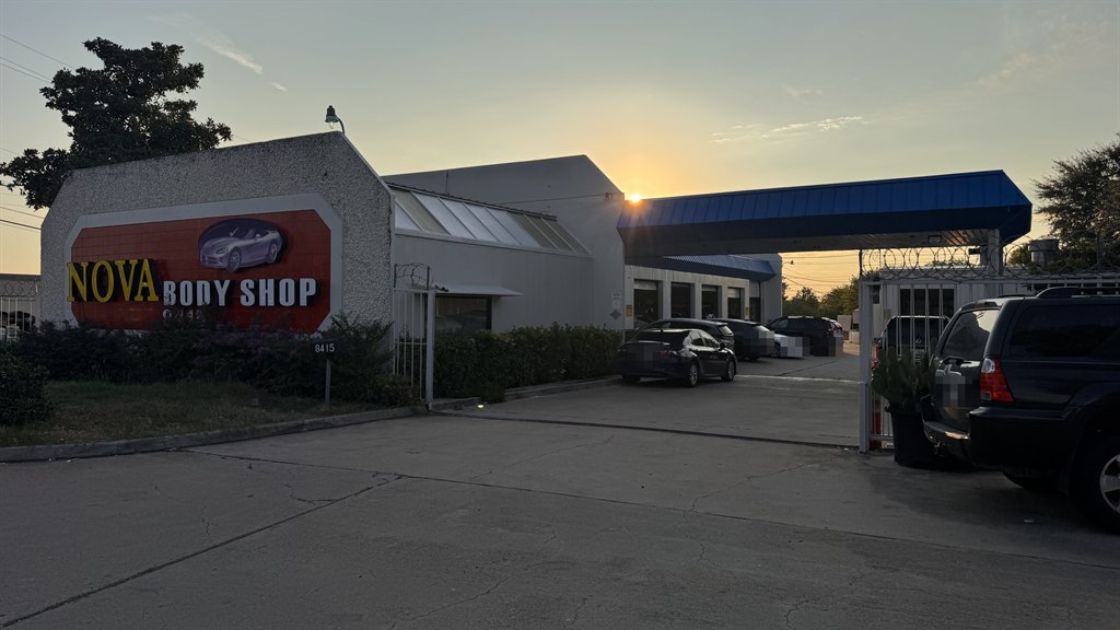 El letrero, la oficina y el techo de servicio de Nova Body Shop en North Lamar al atardecer